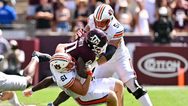 Sep 23, 2023; College Station, Texas, USA; Auburn Tigers long snapper Reed Hughes (61) and offensive lineman Tate Johnson (54) tackle Texas A&M Aggies wide receiver Ainias Smith (0) on a punt return in the third quarter at Kyle Field. Mandatory Credit: Maria Lysaker-USA TODAY Sports  